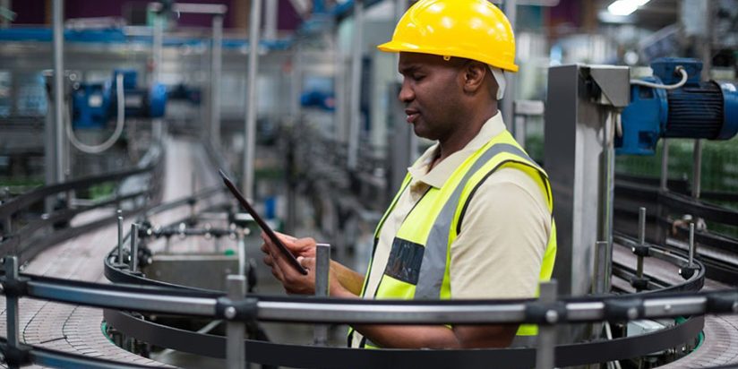 Factory worker using a digital tablet near the production line MES